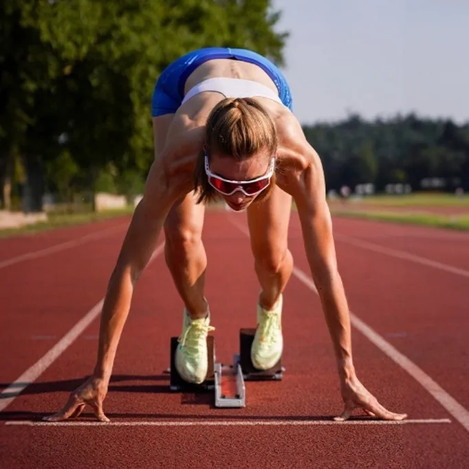 Femme sur une ligne de départ, avec des lunettes de sport pour la course à pieds, disponible à Nanterre, dans les Hauts-de-Seine