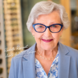 Une cliente très satisfaite de ses lunettes, porte des lunettes bleues à pois blanc de la marque L.A.Eyeworks, achetées chez TOUT'Optique, avec une monture conseillée par nos opticiens visagistes